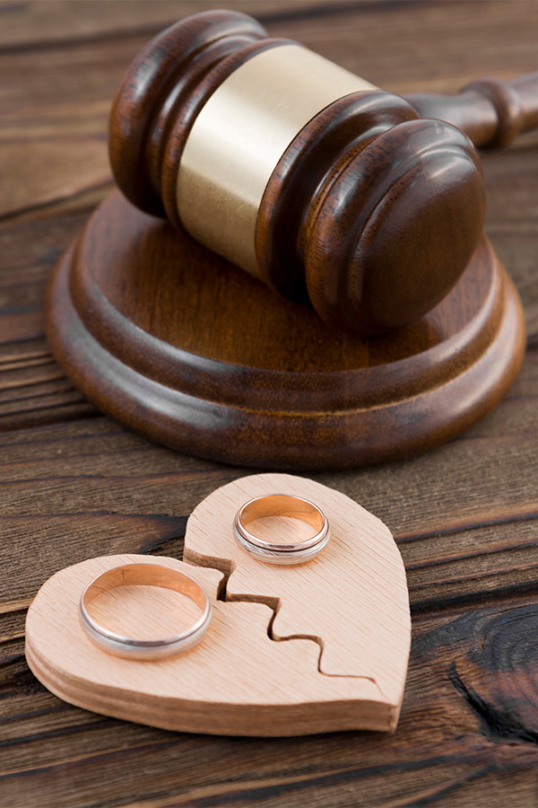 gavel and wooden broken heart with rings laying on it