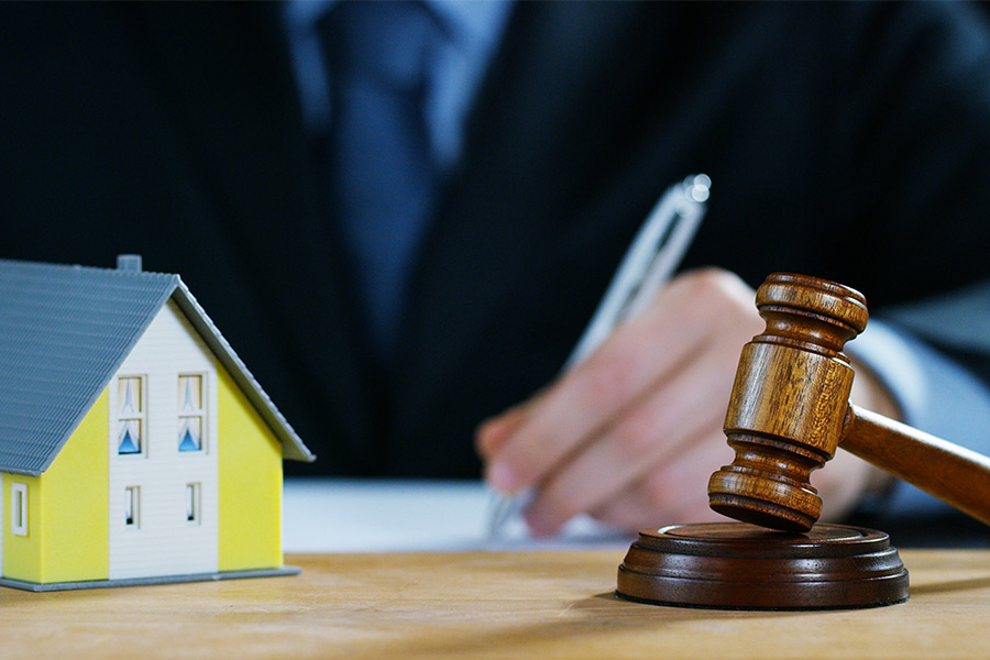 small house model and gavel in front of agent