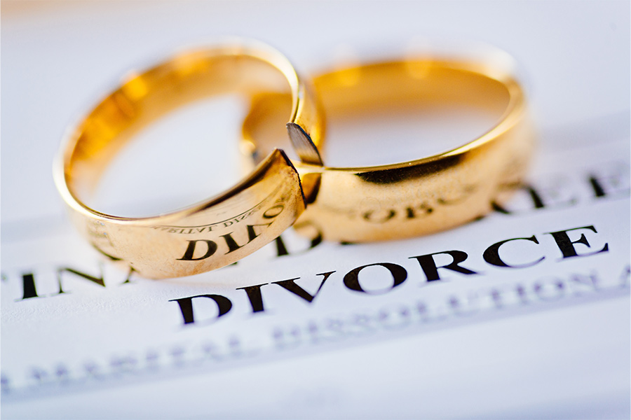wedding rings on top of divorce papers